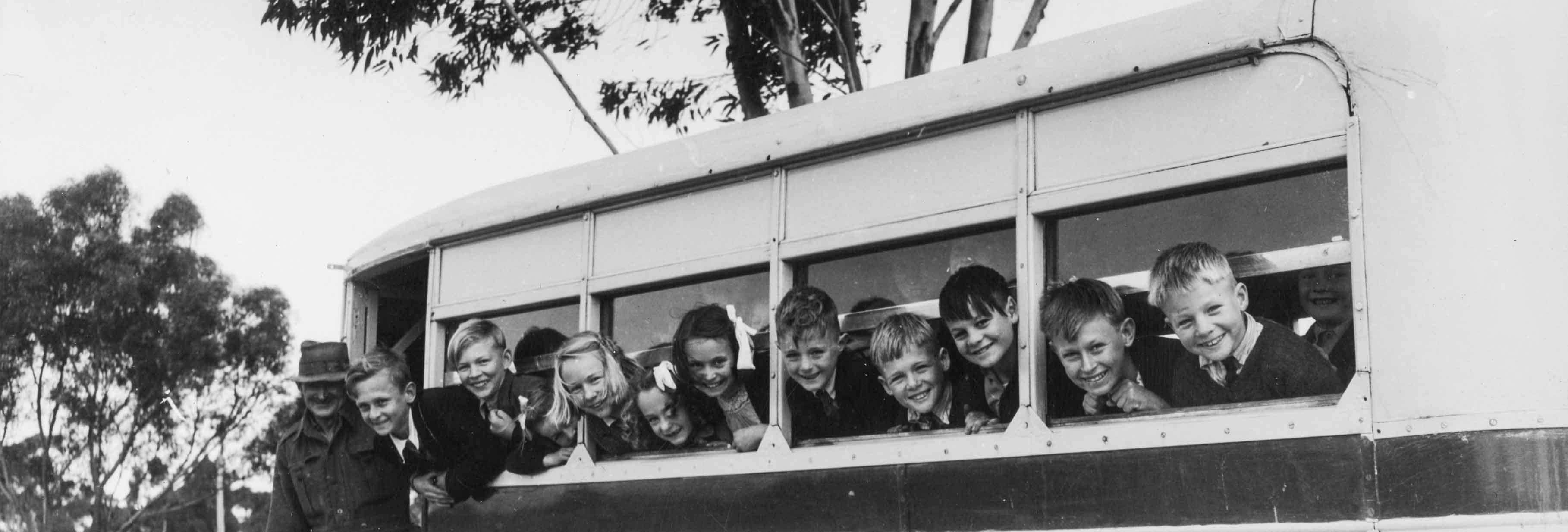 Black and white photo of kids on a school bus